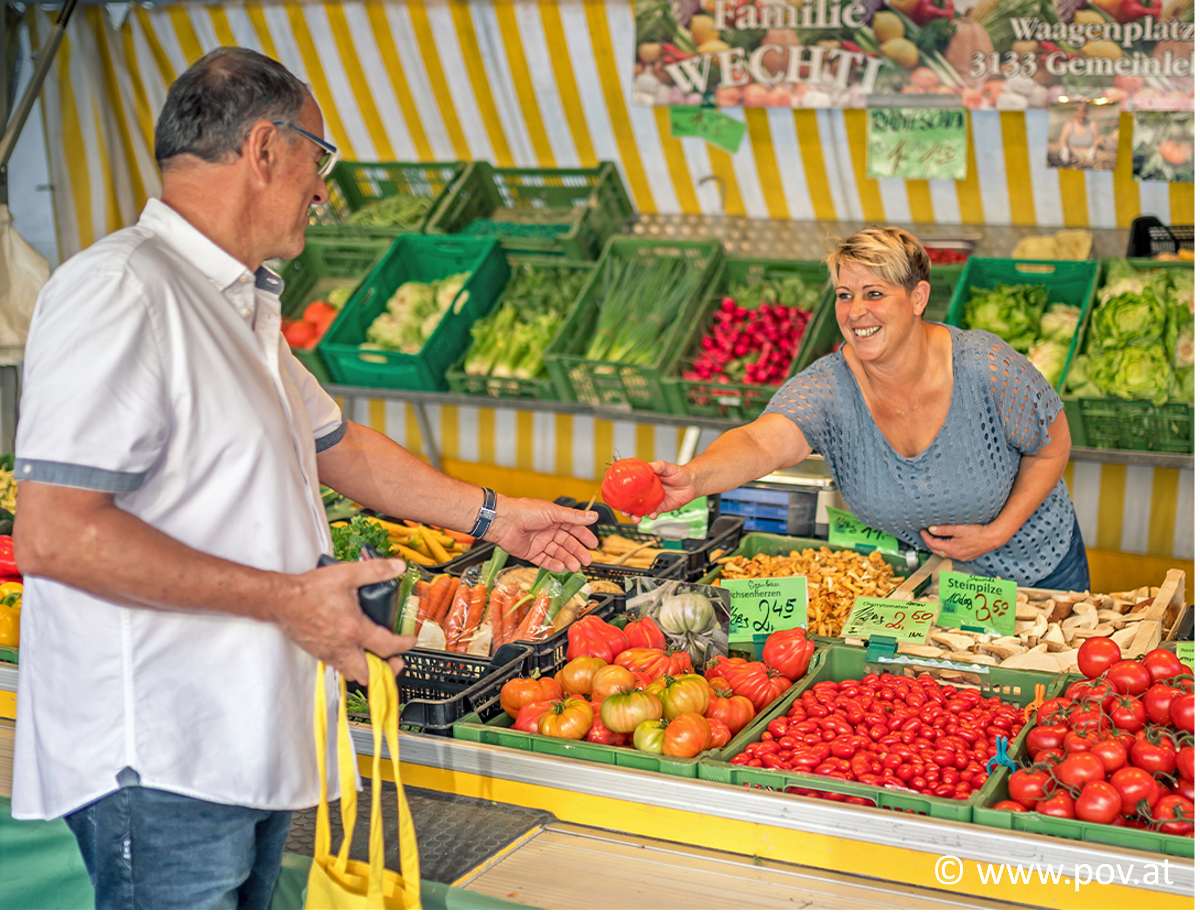 Mann kauft auf einem Markt Gemüse